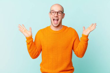 Kel adam mutlu, heyecanlı, şaşırmış ya da şok olmuş hissediyor, gülümsüyor ve inanılmaz bir şeye şaşırıyor.