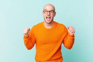 Kel adam şaşkın, heyecanlı ve mutlu hissediyor, gülüyor ve başarıyı kutluyor,!