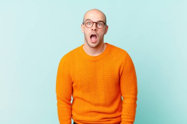 Kel adam şok olmuş ya da şaşırmış görünüyor, ağzı açık bir şekilde 