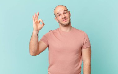 Kel adam mutlu, rahat ve tatmin olmuş hissediyor. Onayını iyi bir hareketle gösteriyor. Gülümsüyor.