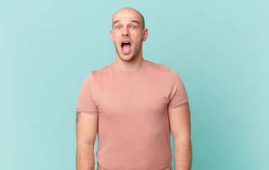 Kel adam şok olmuş ya da şaşırmış görünüyor, ağzı açık bir şekilde 