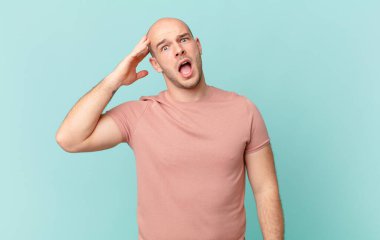 Kel adam mutlu, şaşkın ve şaşırmış görünüyor, gülümsüyor ve inanılmaz ve inanılmaz iyi haberleri fark ediyor.