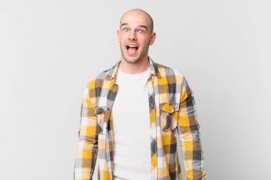 Kel adam şok olmuş ya da şaşırmış görünüyor, ağzı açık bir şekilde 