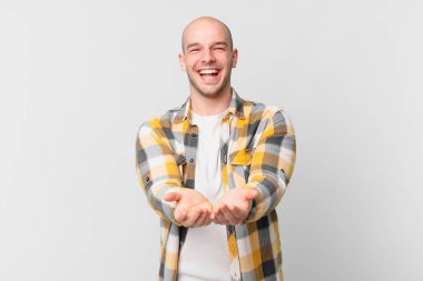 Dost canlısı, kendine güvenen, olumlu bakışlı, bir nesne ya da konsept sunan ve gösteren kel bir adam.