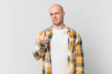 Kel adam kızgın, sinirli, asi ve agresif hissediyor, orta parmağını sallıyor, karşı koyuyor.