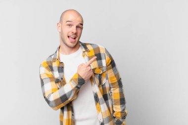 Kel adam heyecanlı ve şaşırmış görünüyor. Yana ve yukarıya bakıp boşluğu kopyalıyor.