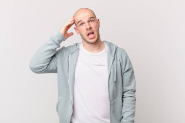 Kel adam mutlu, şaşkın ve şaşırmış görünüyor, gülümsüyor ve inanılmaz ve inanılmaz iyi haberleri fark ediyor.