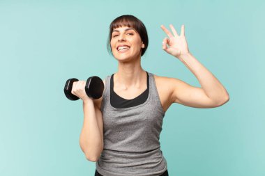 Dambılı genç fitness kadını.