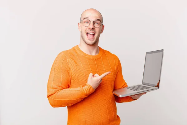 Homem Careca Com Computador Olhando Animado Surpreso Apontando Para Lado — Fotografia de Stock