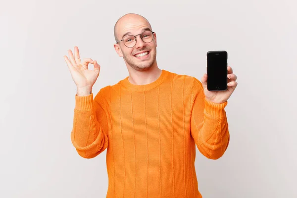 Łysy Mężczyzna Smartfonem Szczęśliwy Zrelaksowany Zadowolony Okazujący Aprobatę Dobrym Gestem — Zdjęcie stockowe