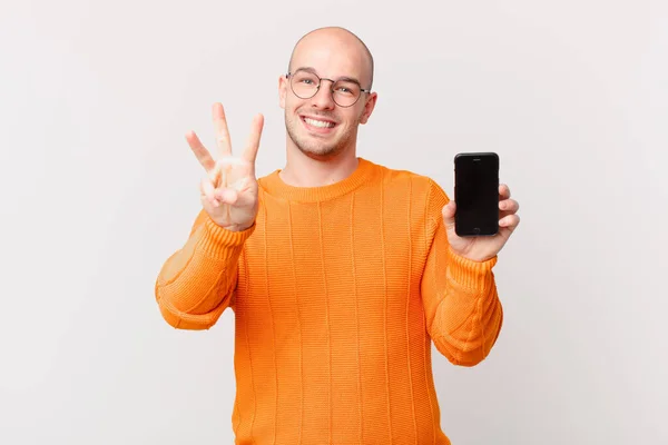 Hombre Calvo Con Teléfono Inteligente Sonriendo Mirando Amigable Mostrando Número —  Fotos de Stock