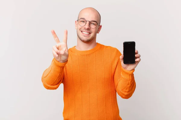 Hombre Calvo Con Teléfono Inteligente Sonriendo Mirando Amigable Mostrando Número —  Fotos de Stock
