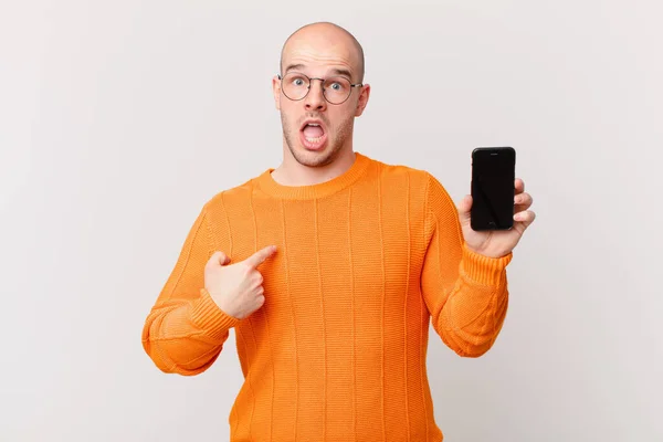 Skallig Man Med Smartphone Ser Chockad Och Förvånad Med Munnen — Stockfoto