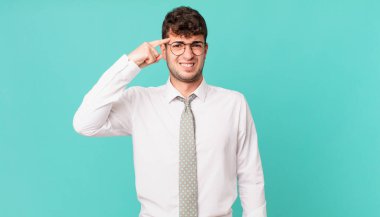 Genç işadamı kafası karışık ve şaşkın hissediyor. Deli, deli ya da aklını kaçırmış olduğunu gösteriyor.