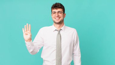 Genç işadamı gülümsüyor ve arkadaş canlısı görünüyor, 4 ya da 4 numarayı gösteriyor, elleri önde, geriye doğru sayıyor.