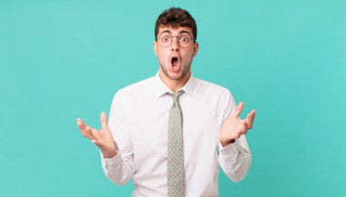 Genç işadamı ağzı açık ve şaşırmış, şok olmuş ve hayrete düşmüş.
