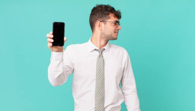 Profil görünümünde akıllı telefonlu bir iş alanı kopyalamak istiyor, düşünüyor, hayal ediyor ya da hayal kuruyor