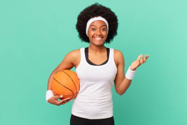 Afro kadın kendini mutlu, şaşırmış ve neşeli hissediyordu. Olumlu bir tavırla gülümsüyordu. Bir çözüm ya da fikir buluyordu. Basketbol konsepti