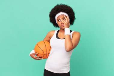 Yorucu, sıkıcı ve can sıkıcı bir görevden sonra sıkılmış, hayal kırıklığına uğramış ve uykulu hisseden afro bir kadın. El ele tutuşarak. Basketbol konsepti  