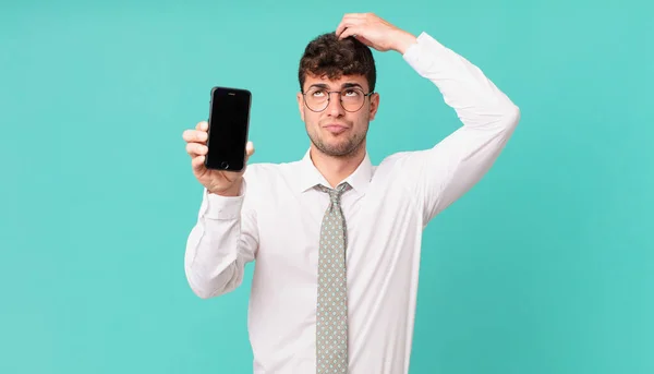 Negocio Con Teléfono Inteligente Siente Perplejo Confundido Arañando Cabeza Mirando —  Fotos de Stock