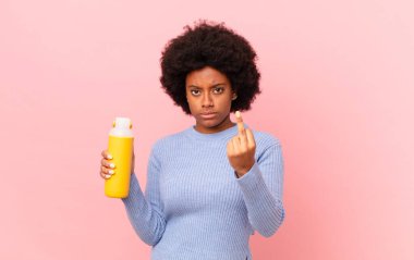 Afro kadın kızgın, sinirli, asi ve agresif hissediyor, orta parmağını sallıyor, karşı koyuyor. pürüzsüz konsept