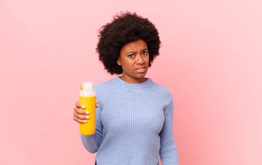 afro woman feeling puzzled and confused, with a dumb, stunned expression looking at something unexpected. smoothy concept