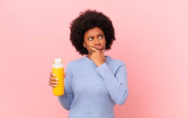 Afro kadın düşünüyor, kuşkulu ve şaşkın hissediyor, farklı seçeneklerle, hangi kararı vereceğini merak ediyor. pürüzsüz konsept