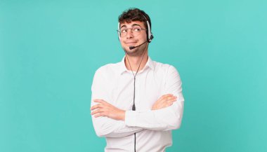 Tele-pazarlamacı omuz silkiyor, kafası karışık ve emin değil, kolları bağlı ve şaşkın görünüyor.