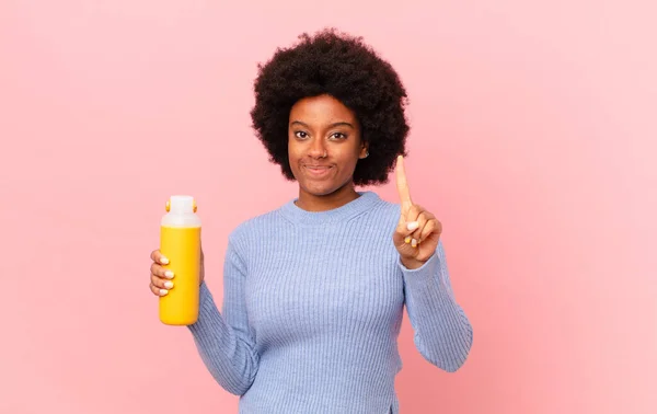 Afro Mujer Sonriendo Buscando Amigable Mostrando Número Uno Primero Con —  Fotos de Stock