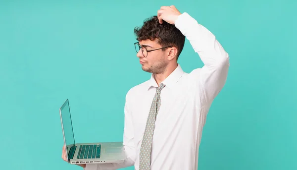 Empresário Com Laptop Sentindo Intrigado Confuso Coçando Cabeça Olhando Para — Fotografia de Stock