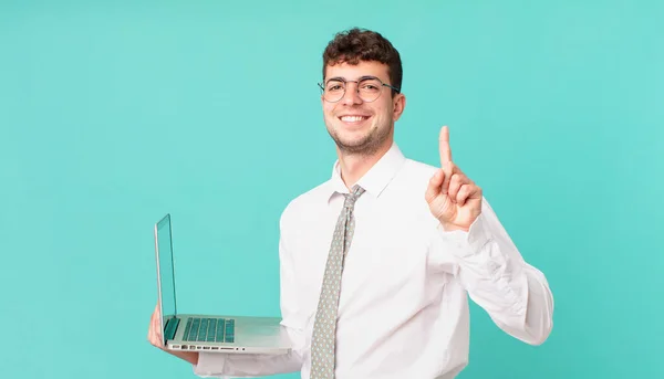 Hombre Negocios Con Portátil Sonriendo Mirando Amigable Mostrando Número Uno —  Fotos de Stock