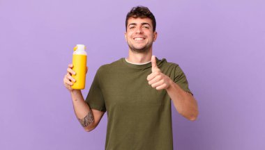 Gururla gülümseyen, gururla gülümseyen, bir numaralı pozu veren, kendini lider gibi hisseden bir adam.