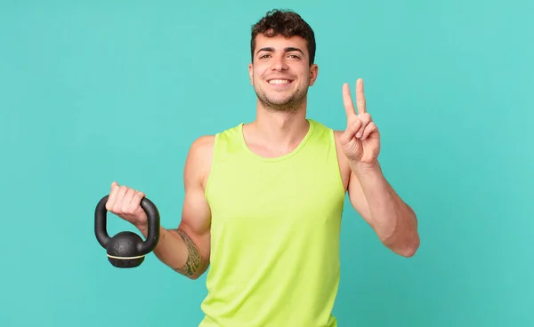 Fitnessman Glimlachend Vriendelijk Uitziend Nummer Twee Tweede Met Hand Naar — Stockfoto