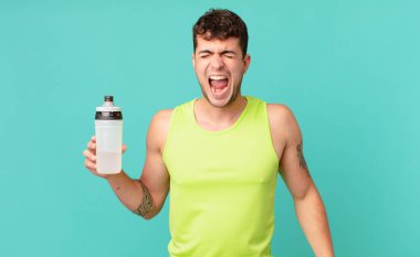Fitness adamı agresif bir şekilde bağırıyor, çok kızgın, sinirli, öfkeli ya da sinirli görünüyor, haykırmıyor