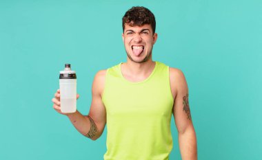 Fitness adamı tiksinmiş ve sinirlenmiş hissediyor, dilini dışarı çıkarıyor, iğrenç ve iğrenç bir şeyden hoşlanmıyor.