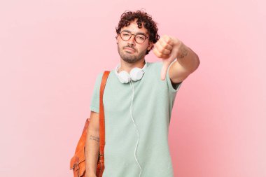 Hispanik öğrenci kızgın, sinirli, hayal kırıklığına uğramış ya da hoşnutsuz, ciddi bir bakışla başparmaklarını göstermiyor.