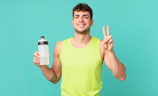 Homem Fitness Sorrindo Olhando Amigável Mostrando Número Dois Segundo Com — Fotografia de Stock