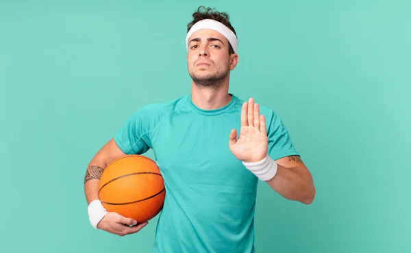 fitness man looking serious, stern, displeased and angry showing open palm making stop gesture