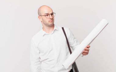 Mimar üzgün, üzgün ya da kızgın hissediyor ve olumsuz bir tavır takınıyor, anlaşmazlık içinde kaşlarını çatıyor