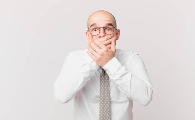 Kel iş adamı şok olmuş, şaşırmış bir ifadeyle ağzı kapatıyor, sır saklıyor ya da 