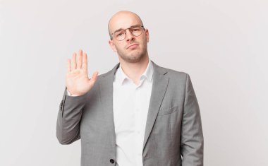 Kel iş adamı ciddi, sert, hoşnutsuz ve kızgın görünüyor.