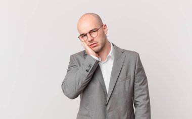 Kel iş adamı, yorgun, sıkıcı ve can sıkıcı bir işten sonra sıkılmış, hayal kırıklığına uğramış ve uykulu hisseder.