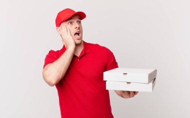 Pizza dağıtan adam mutlu, heyecanlı ve şaşırmış hissediyor, iki eli yüzü yana bakıyor.