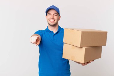 Paket teslimatı yapan adam kameraya tatmin olmuş, kendinden emin, dostane bir gülümsemeyle bakıyor ve seni seçiyor.