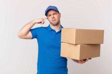 Paket teslim adam kafası karışık ve şaşkın hissediyor, deli, deli ya da aklını kaçırmış olduğunu gösterir