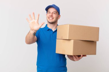 Paket teslimatçısı güler yüzlü ve arkadaş canlısı görünüyor, 5 ya da 5 numarayı gösteriyor, eli önde, geri sayıyor.