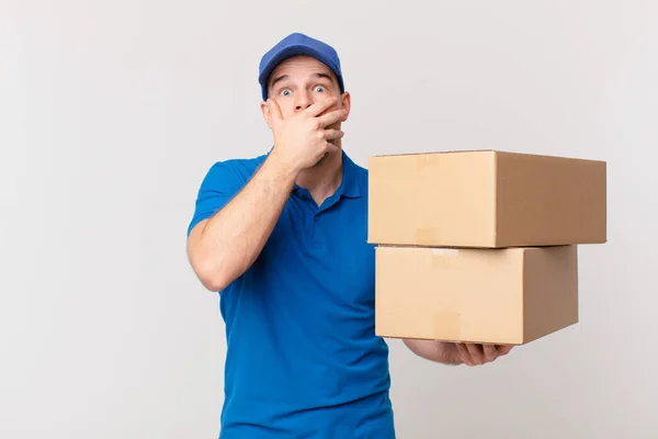 Paket Leverera Man Täcka Munnen Med Händerna Med Chockad Förvånad — Stockfoto