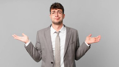 İş adamı şaşkın ve şaşkın hissediyor, şüpheci, farklı seçenekleri tartıyor ya da komik ifadeyle seçiyor