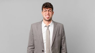 İş adamı tiksinti ve tedirginlik duyuyor, dilini dışarı çıkarıyor, iğrenç ve iğrenç bir şeyden hoşlanmıyor.