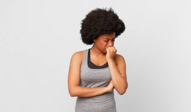 Siyah afro kadın ciddi, düşünceli ve endişeli, elleri çenesine bastırılmış, yan bakıyor